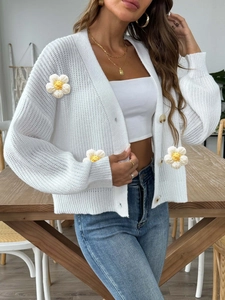 Women's white knitted cardigan featuring handmade daisy floral details and button front
