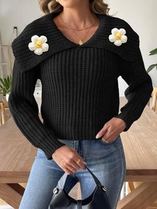 Women's black knit sweater with large collar and white crochet flower accents