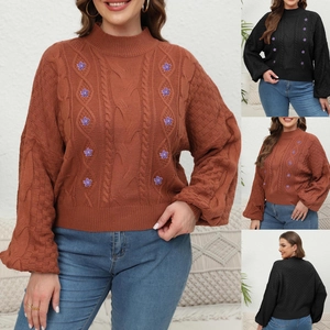 Detail of cable knit sweater featuring floral appliques and lantern sleeve texture