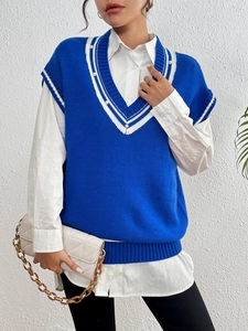 Dettaglio dello scollo a V del gilet in maglia con perle e strisce a contrasto