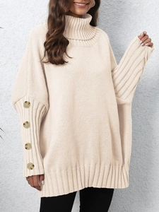 Women's cream oversized turtleneck sweater featuring decorative buttons on the ribbed cuffs