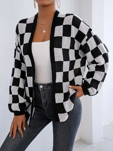 Dettaglio del cardigan in maglia a scacchi bianchi e neri con polsini a costine da donna