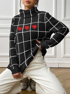 Detail of a black turtleneck sweater featuring white plaid patterns and red heart embroidery