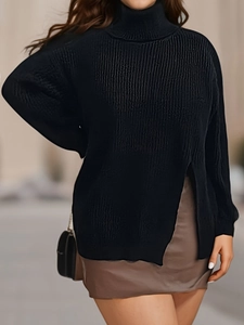 Detail view of black high collar knit sweater featuring stylish side slit and ribbed texture