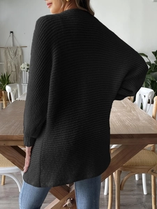 Vue arrière d'un gilet en maille noire avec texture côtelée et épaules tombantes