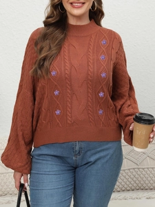Detail of red-brown chunky cable knit sweater with purple floral embroidery and lantern sleeves