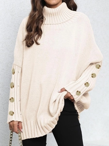 Detailed texture of off-white chunky knit sweater with decorative marble buttons on cuffs