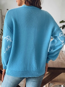 Detail view of sky blue Halloween cardigan with white ghost knit patterns on the back