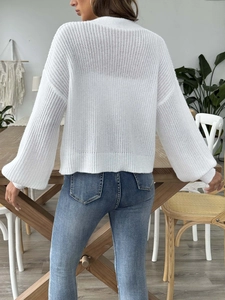 Detailed back view of white hollow-out knit cardigan with ribbed hem and cuffs