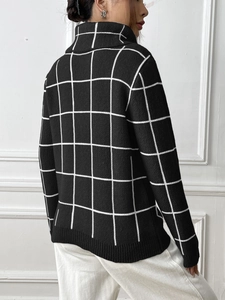 Detail view of black high neck sweater with classic white grid pattern and ribbed cuffs