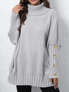 Detail of light grey knit sweater featuring batwing sleeves and amber buttons on cuffs