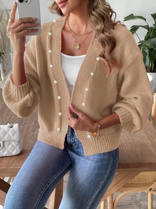 Detail of khaki chunky knit cardigan with elegant pearl beads and textured woven pattern