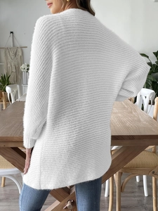 Détail du tricot blanc pelucheux en maille de plumes sur un cardigan ample pour femme