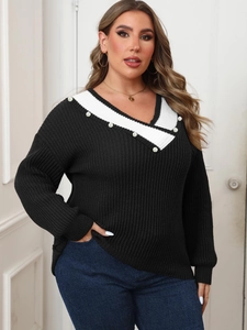 Detail of plus size black ribbed sweater featuring contrast V-neck and pearl bead accents