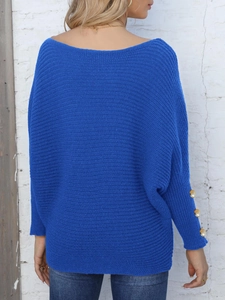 Detail of royal blue batwing sleeve sweater featuring elegant gold buttons on cuffs