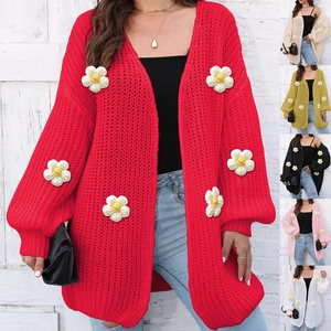Close-up of chunky knit cardigan featuring 3D daisy appliques and textured weave