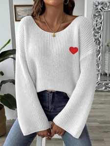 Detailed view of red heart embroidery patch on white off-shoulder knit sweater