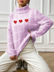 Detail of light purple turtleneck sweater with white grid pattern and red heart embroidery