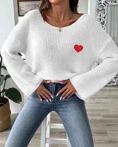 Detail of red heart embroidery patch on white chunky knit sweater for women