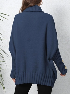 Detail of dark blue knit sweater showing turtleneck collar and wood buttons on cuffs