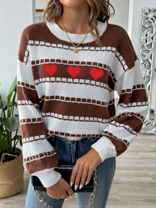 Detail of striped knit sweater with red heart embroidery and crocodile chain bag