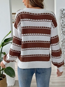 Detailed knit texture of a brown and white striped sweater with a drop shoulder design