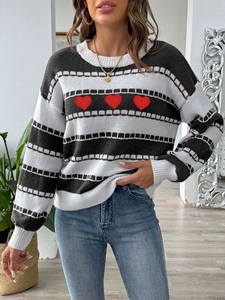 Detail of red heart embroidery on a black and white striped knitted sweater for women