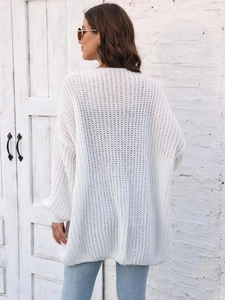 Close-up back view of a white oversized chunky knit cardigan with lantern sleeves