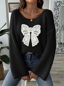 Maglione nero da donna in maglia con grande fiocco di pizzo bianco e maniche svasate