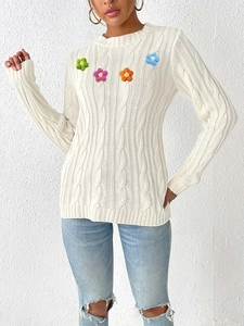 Women's white round neck cable-knit sweater featuring colorful handmade floral patches