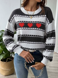 Detail of three red heart embroidery on black and white striped knit sweater for women