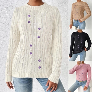 Detail of floral embroidery on a crewneck cable knit sweater with four color variants
