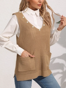 Dettaglio del gilet in maglia con scollo a V, bottoni di perle e doppie tasche anteriori