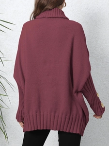 Detail of burgundy oversized sweater showing ribbed hem and buttons on sleeve cuff