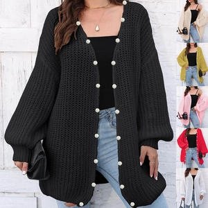 Detail of chunky knit cardigan featuring pearl buttons and stylish lantern sleeves