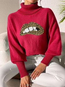 Detail of fuchsia turtleneck sweater featuring sequined leopard print lip embroidery