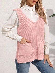 Dettaglio del gilet in maglia rosa con decorazioni di perle lungo lo scollo a V