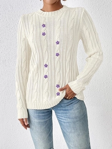 Close-up of off-white cable knit sweater featuring purple flower embroidery and round neck