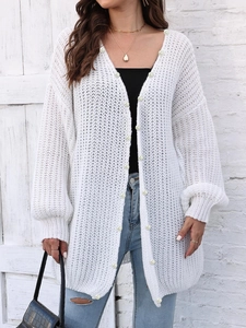 Detailed knit texture and faux pearl buttons on white long oversized cardigan