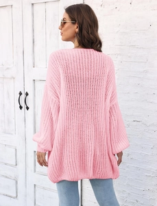 Detail of pink chunky knit texture and oversized loose sleeve on a long cardigan