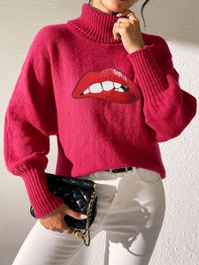 Detail of hot pink turtleneck knit sweater with sequined lip pattern and ribbed collar