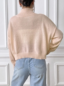 Rear view of women's high-neck peach knit sweater with ribbed cuffs and drop shoulder detail