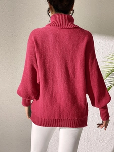 Rear view of rose red turtleneck knit sweater showing thick texture and ribbed cuffs