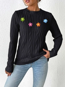 Women's black cable knit sweater featuring 3D colorful crochet flower appliques and crew neck