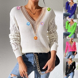 Detail view of V-neck lace crochet edge and 3D floral appliques on knit sweater