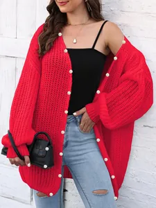 Detail of red chunky knit cardigan featuring cable stitch texture and ribbed cuffs