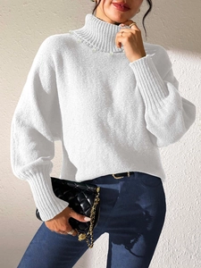 Detail of white turtleneck knit sweater with delicate pearl accents and puff sleeves