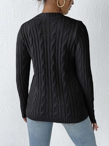 Detail view of the black knit sweater back featuring a classic cable knit texture pattern