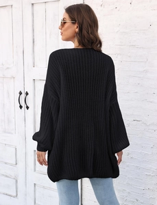 Detail view of the chunky knit texture and oversized back cut of the black cardigan sweater