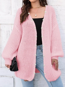 Close-up of pink knit cardigan showing hollow-out texture and white pearl buttons